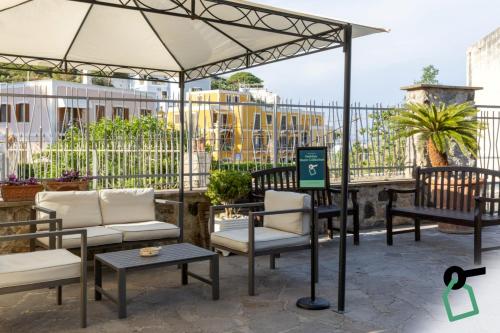 a patio with chairs and an umbrella at Hotiday Ponza Scogliera in Ponza
