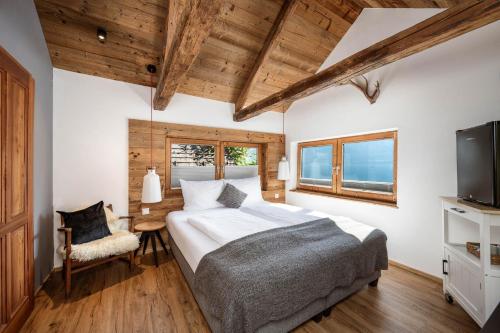 a bedroom with a large bed and a television at Seehaus 96 Hallstatt in Hallstatt
