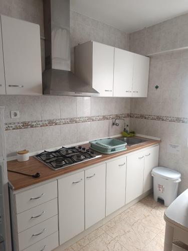 a kitchen with white cabinets and a stove top oven at Apartamento Junto AL MAR Quesada 2 in Almería