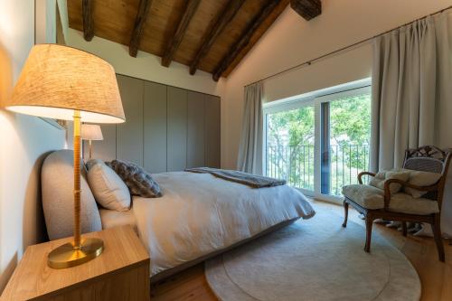 a bedroom with a bed and a lamp and a chair at Dimora Riccio in Dalegna del Collio