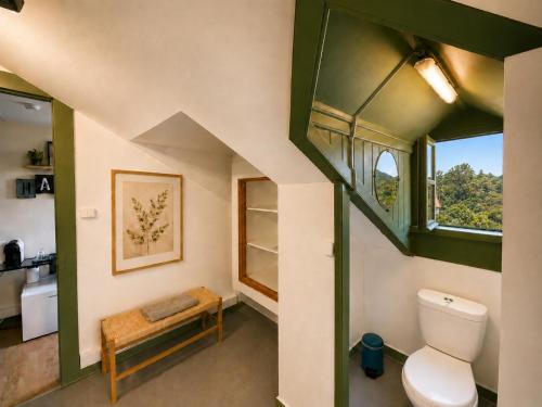 an attic bathroom with a toilet and a window at Happy Holiday Sintra Guesthouse & Breakfast in Sintra