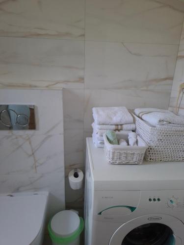 a white bathroom with a washing machine and towels at Lagonissi Summer House in Lagonissi