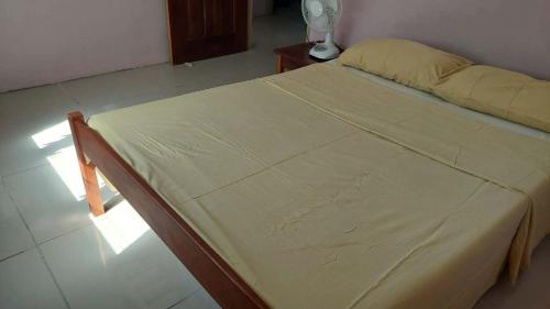 a bed with a yellow blanket on it in a room at Vatudei Homestay - Yasawa Islands in Somosomo