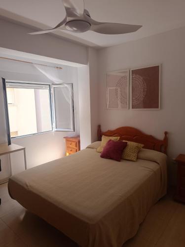 a bedroom with a bed and a ceiling fan at Apartamento Junto AL MAR Quesada 2 in Almería