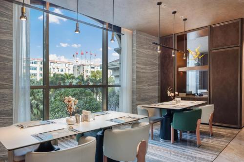 a restaurant with tables and chairs and a large window at Marco Polo Jin Jiang in Jinjiang