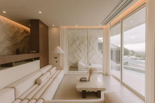 a living room with a white couch and a large window at Fira Uluwatu in Uluwatu
