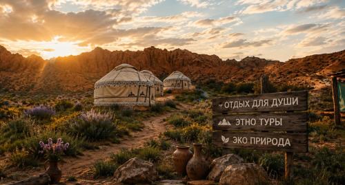 a desert with two domes and a sign in the desert at Kyzyl-Jar in Kaji-Say
