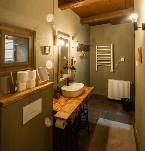 a bathroom with a sink on a wooden counter at Gyimesi Skanzen in Valea Boroş