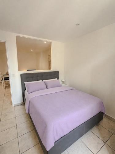 a bedroom with a large bed with purple sheets at Les studios du Général - Lavande in Saint-Maximin-la-Sainte-Baume