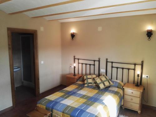 a bedroom with a bed with two night stands and two lamps at Casa Rural La Granja in Letur