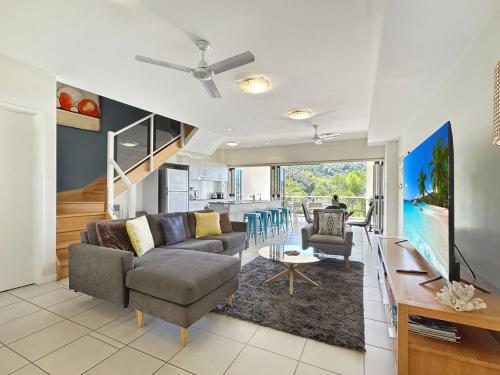 a living room with a couch and a table at Beachside Apartment 14 in Nelly Bay