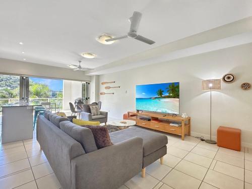 a living room with a couch and a flat screen tv at Beachside Apartment 14 in Nelly Bay