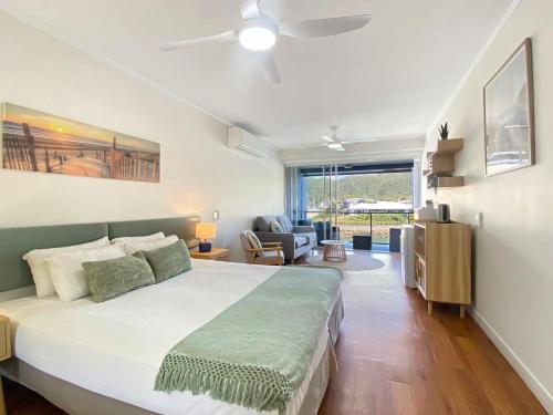 a bedroom with a large bed and a living room at Blue on Blue Studio Room 1222 in Nelly Bay