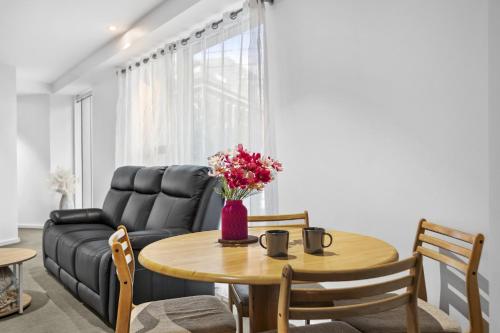 a living room with a table and a couch at Stylish 2-Bed Apartment by 888 Collins in Melbourne