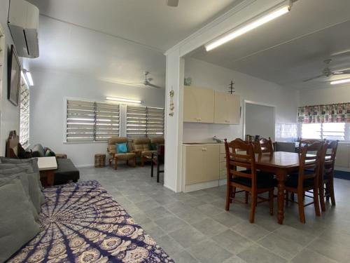 a kitchen and a living room with a table and chairs at Whitehaven 2 in Picnic Bay