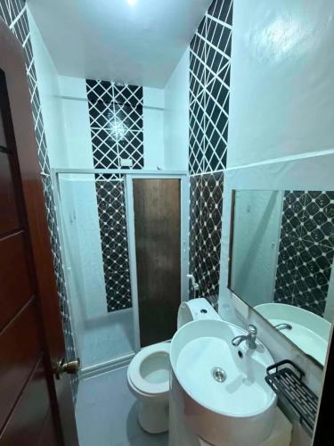 a bathroom with a sink and a toilet and a mirror at DC Travellers Inn Unit E 3rd Fl in Malolos