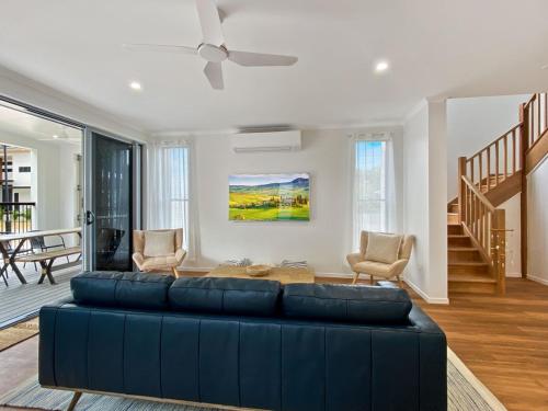a living room with a blue couch and a ceiling fan at Picnic Point in Picnic Bay