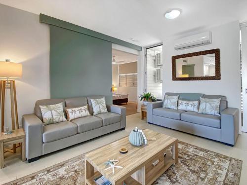 a living room with a couch and a table at 1 Bright Point Apartment 1407 in Nelly Bay