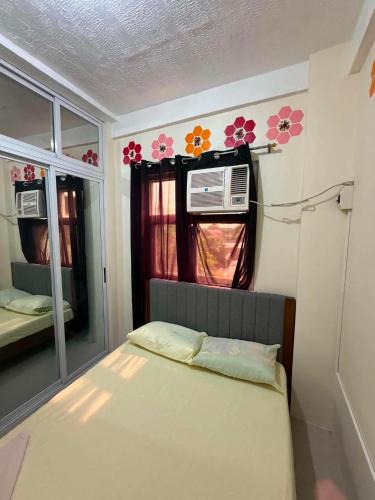 a small room with a bed and a window at DC Travellers Inn Unit E 3rd Fl in Malolos