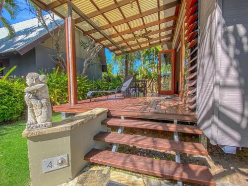a wooden deck with a bench on a house at Pure Magnetic Villa 4 in Nelly Bay