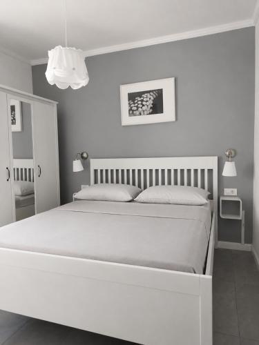 a white bedroom with a large white bed in it at Apartments Merlin in Novigrad Istria