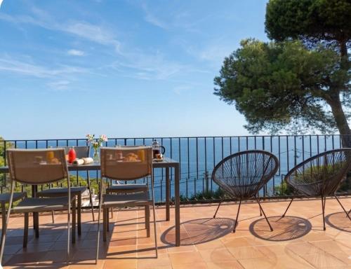 a table and three chairs and a table and a table and chairs at La Terrasse 1-Vue Mer Panoramique & Piscine, BBQ in Begur