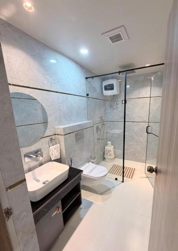 a bathroom with a toilet and a sink and a shower at Hotel MEDHA Inn in Patna