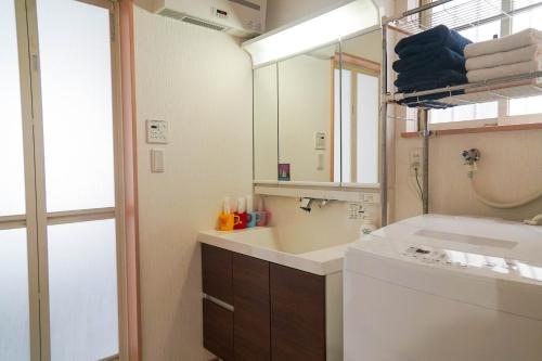 a bathroom with a sink and a washing machine at Katsuragawa House in Kami-tobachō