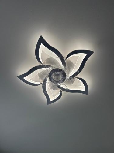a ceiling light with a black and white flower on a ceiling at Northern Lights small apartment A at Emmas Street 28, Riga in Riga
