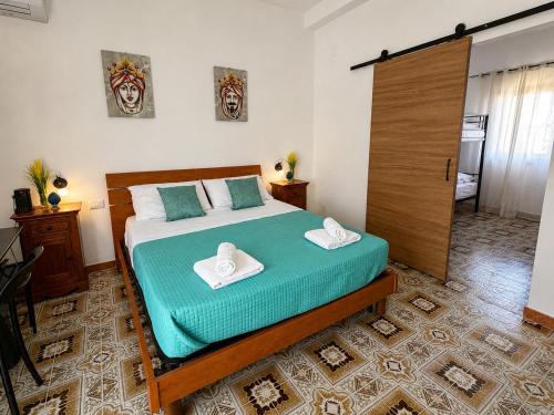 a bedroom with a bed with two towels on it at O'Chianu in Lascari