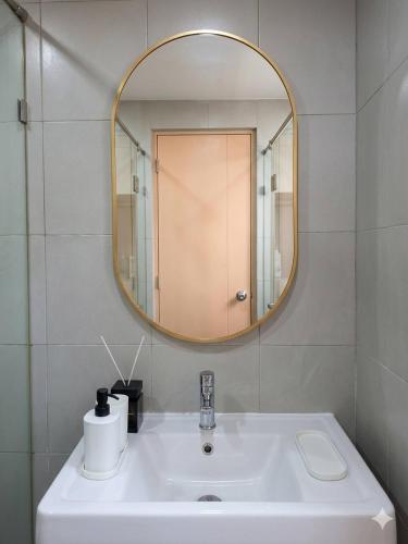 a bathroom with a white sink and a mirror at Modern Studio Pool View, King bed, BTS Punnawithi in Bangkok