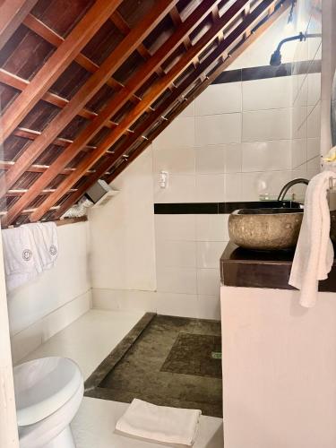 a bathroom with a sink and a toilet at The Palms Ceningan Hotel in Nusa Lembongan