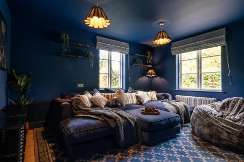 a blue living room with a couch and chairs at Finest Retreats - The Old Schoolhouse at Penrhos in Raglan