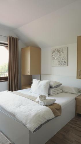 a large white bed in a room with a window at Pensiunea Smiley in Turda