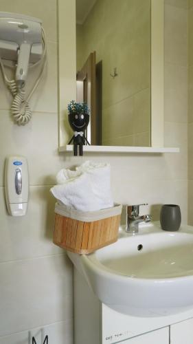 a bathroom with a sink and a mirror and towels at Pensiunea Smiley in Turda