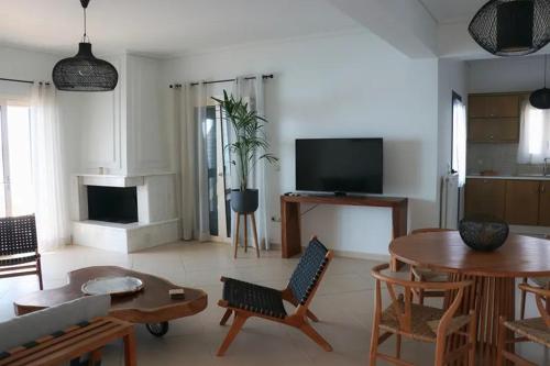 a living room with a couch and a table at Grand Bleu Apartments & Villas in Ermioni