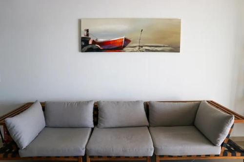 a couch in a living room with a picture on the wall at Grand Bleu Apartments & Villas in Ermioni
