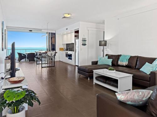 a living room with a couch and a table at 1 Bright Point Apartment 4501 in Nelly Bay