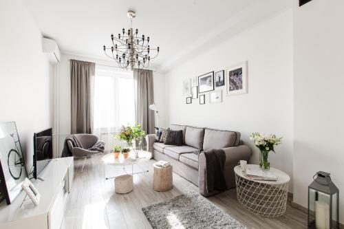 - un salon blanc avec un canapé et une table dans l'établissement Apartament Plac Zbawiciela, à Varsovie
