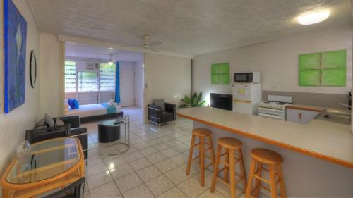 a kitchen and living room with a bar and stools at Loyang Apartment 2 in Arcadia