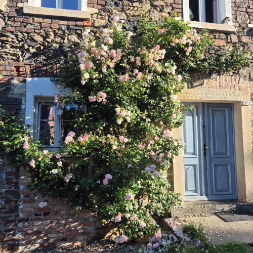 a bush of roses on the side of a building with a door at Pokój i Spokój Agroturystyka in Zacisze