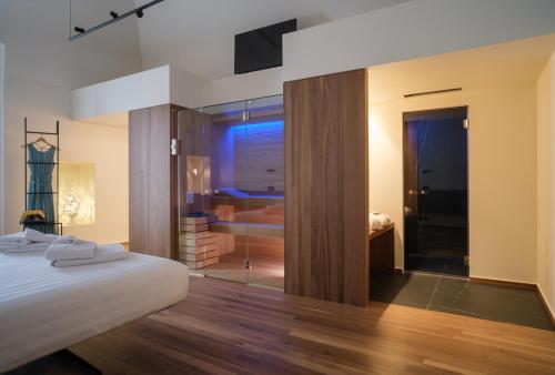 a bedroom with a bed and a walk in shower at Benedamò Home Inside in Polignano a Mare