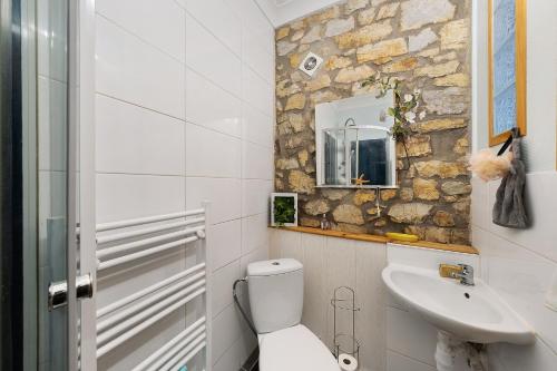 a bathroom with a white toilet and a sink at Appartement centre de Crozon in Crozon