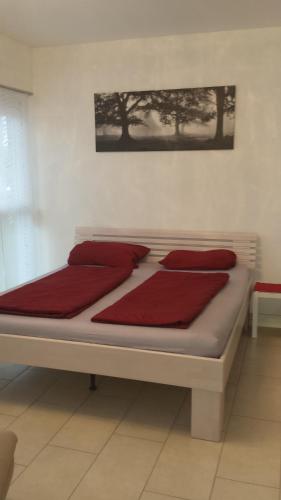 una cama con almohadas rojas en una habitación en Modernes 3-Zimmer-Apartment nahe Graz, en Gratkorn