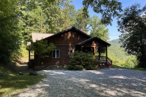 a log cabin in the woods with a porch at Millstone Lodge Cabin in Bryson City