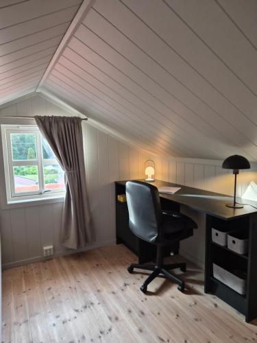 an attic office with a desk and a chair at Garden House 1 in Hvaler