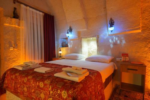 a bedroom with a bed with towels on it at Coco Cave in Göreme