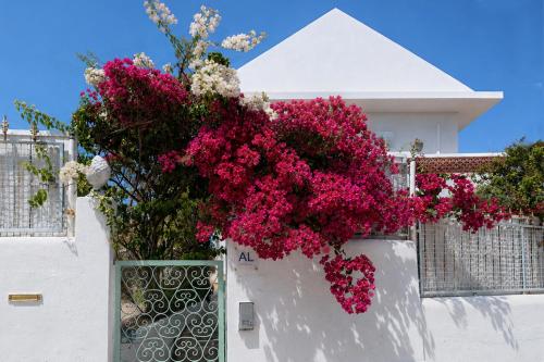 a bunch of pink flowers on a white wall at Casa Branca - Caparica in Charneca