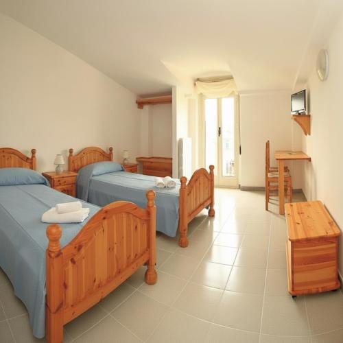 a bedroom with two beds and a table at Borgo Moderno in Irgoli