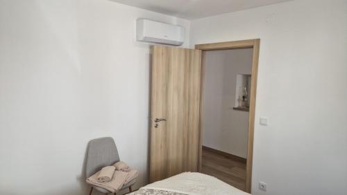 a bedroom with a bed and a chair and a door at Casa do Arco in Aljubarrota